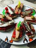 Una de montaditos en clave de sol de pimientos asados bonito y sardinitas en aceite de oliva