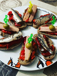Una foto de Una de montaditos en clave de sol de pimientos asados bonito y sardinitas en aceite de oliva