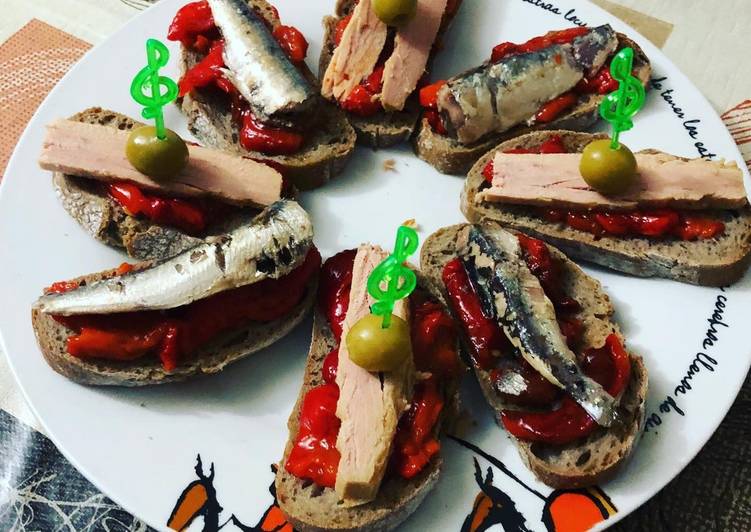 Una de montaditos en clave de sol de pimientos asados bonito y sardinitas en aceite de oliva