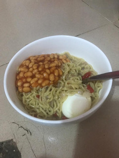 A picture of Noodles with boiled egg and baked beans.