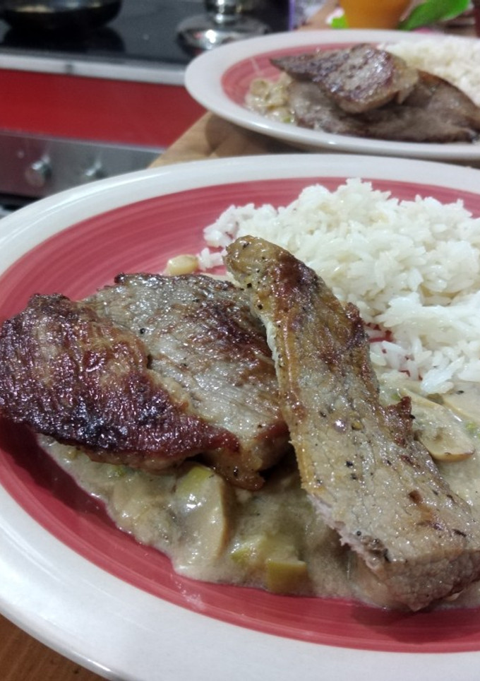 Una foto de Bistec sobre salsa de champiñones