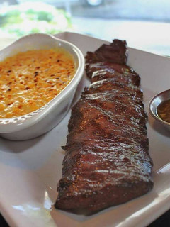 Una foto de Churrasco acompañado de crema de maíz gratinado y salsa de pimentón