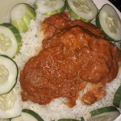 A picture of White rice,stew and cucumber.