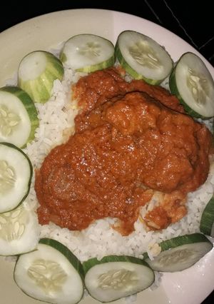 A picture of White rice,stew and cucumber.