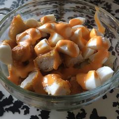 A picture of Salad with chicken nuggets.