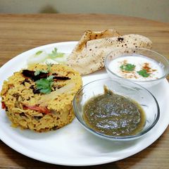 A picture of Lots of vegetables tehiri with green chutney,curd,Pappas,salad.