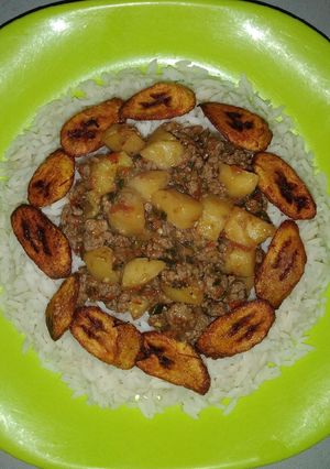 A picture of White rice and plantain with minced meat sauce.