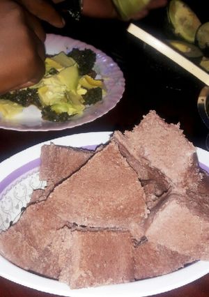 A picture of Brown ugali with veggies and meat.