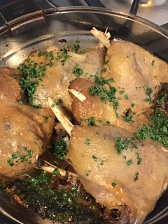 A picture of Oven-Baked Duck Legs with Roasted Garlic and Onion with Parsley.