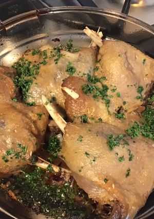 Une photo de Confit de cuisses de canard au four ail et oignon rôtis au persil