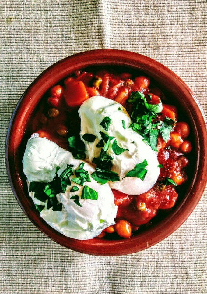 Una foto de Cazuela vegetariana de garbanzos con tomate y huevos poché