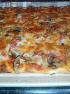 Una foto de Pizza con setas shiitake, cebolla y jamón