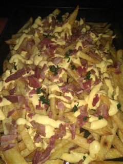 Una foto de Papas fritas con salsa cheddar
