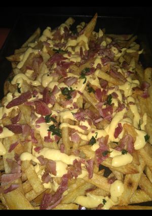 Una foto de Papas fritas con salsa cheddar