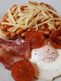 Una foto de English breakfast con alubias, bacon y huevo