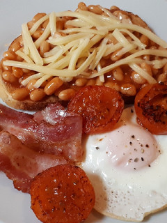 Una foto de English breakfast con alubias, bacon y huevo