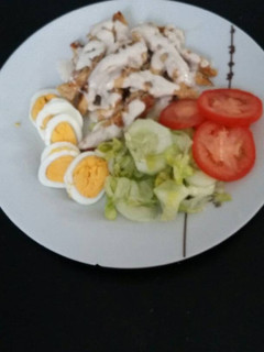 Una foto de Pechuga de pollo bañada en salsa de queso con ensalada y huevo duro