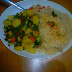 A picture of Buttered rice accompanied by mixed veges with potatoes.