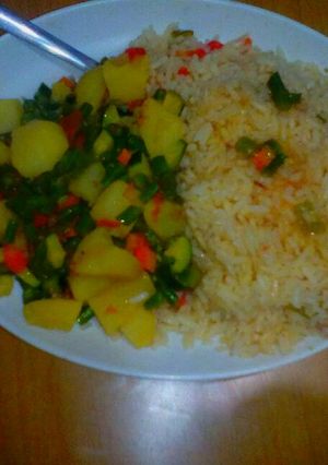 A picture of Buttered rice accompanied by mixed veges with potatoes.