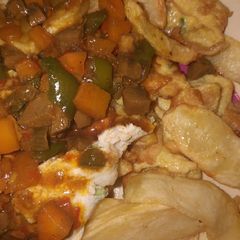A picture of Fried chips with kidney sauce and egg.