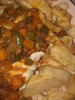 A picture of Fried chips with kidney sauce and egg.