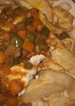 A picture of Fried chips with kidney sauce and egg.