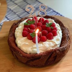 A picture of Flourless chocolate cake with raspberries and cream.