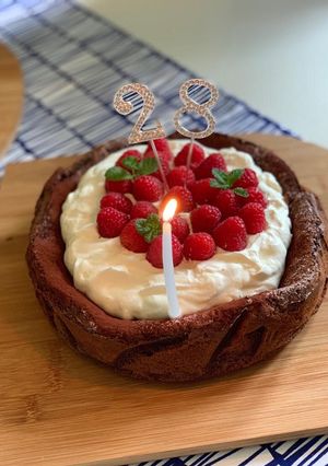 A picture of Flourless chocolate cake with raspberries and cream.