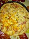 Pizza de jamón de york bacon con doble quesos variados con albahaca a la piedra