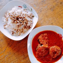 A picture of Rice and beans with fish stew.