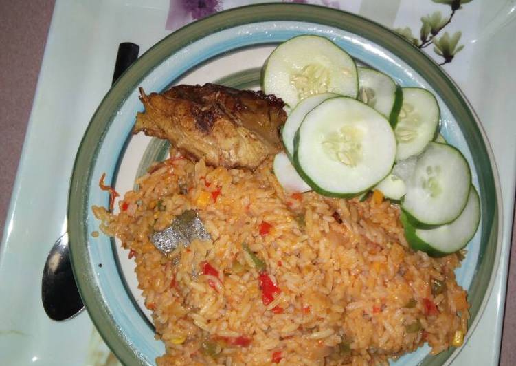 Jollof rice with chicken and sliced cucumber