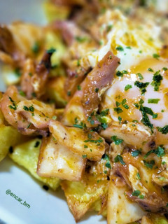 Una foto de Patatas con pota y huevo en tomate