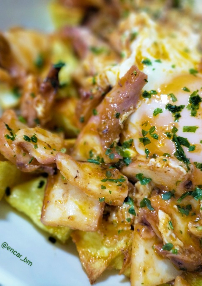 Una foto de Patatas con pota y huevo en tomate