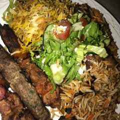 A picture of Fried rice and spaghetti with grilled meat with coleslow.