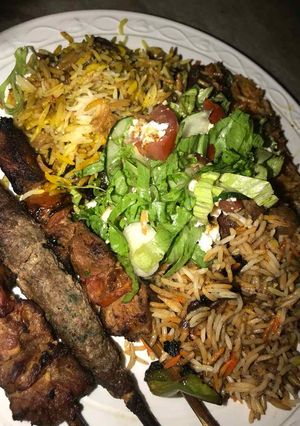 A picture of Fried rice and spaghetti with grilled meat with coleslow.
