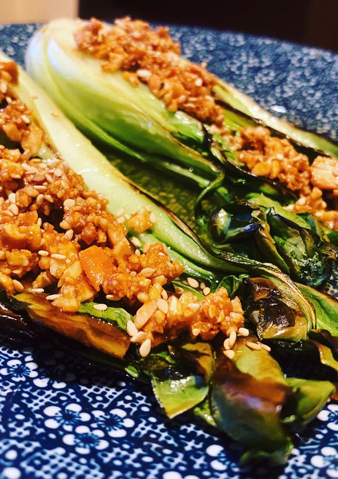 Una foto de Pak choi con anacardos, sésamo y vinagreta de miel y naranja