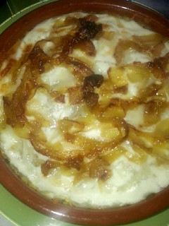 Una foto de Patatas al horno con salchichas fritas y cebolla caramelizada