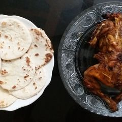 A picture of Grilled chicken with pita bread.