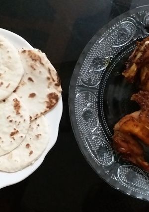 A picture of Grilled chicken with pita bread.