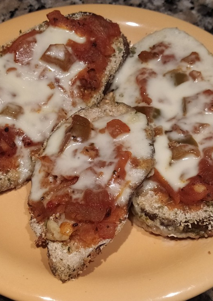Una foto de Milanesa de berenjena al horno, con salsa y queso 🍆🍆
