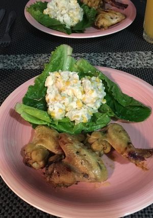 Una foto de Alitas de pollo con ensalada rusa