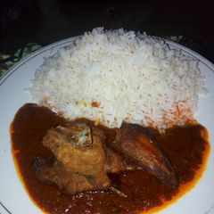 A picture of White rice and chicken stew.