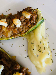 Una foto de Calabacín relleno con cama de puré de patata