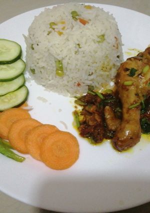 A picture of Fried chicken with vegetable rice.