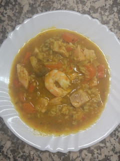 Una foto de Arroz caldoso de salmón, setas y langostinos
