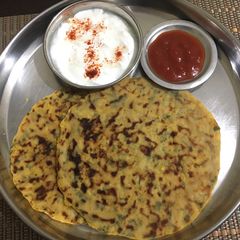A picture of Aloo paratha with curd.