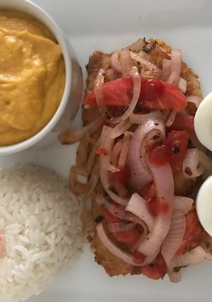 Una foto de Filete de pescado encebollado acompañado de puré de camote y arroz blanco a lo Carmelita