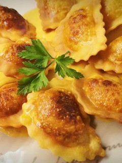 Una foto de Raviolis tostados de Bogavante y Burrata a la crema de Romesco