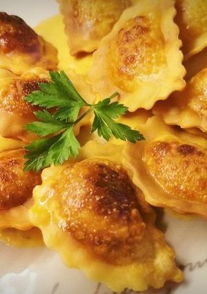 Una foto de Raviolis tostados de Bogavante y Burrata a la crema de Romesco