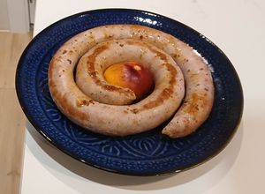 Una foto de Salchicha de Cerdo con Nectarina pochada en reducción de Vino Blanco y Caldo Vegetal